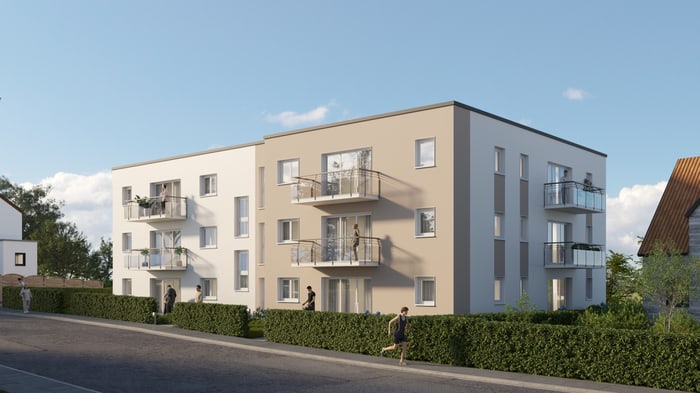 Zwei moderne, vierstöckige Apartmentgebäude mit Balkonen und Hecken entlang einer Straße unter blauem Himmel.